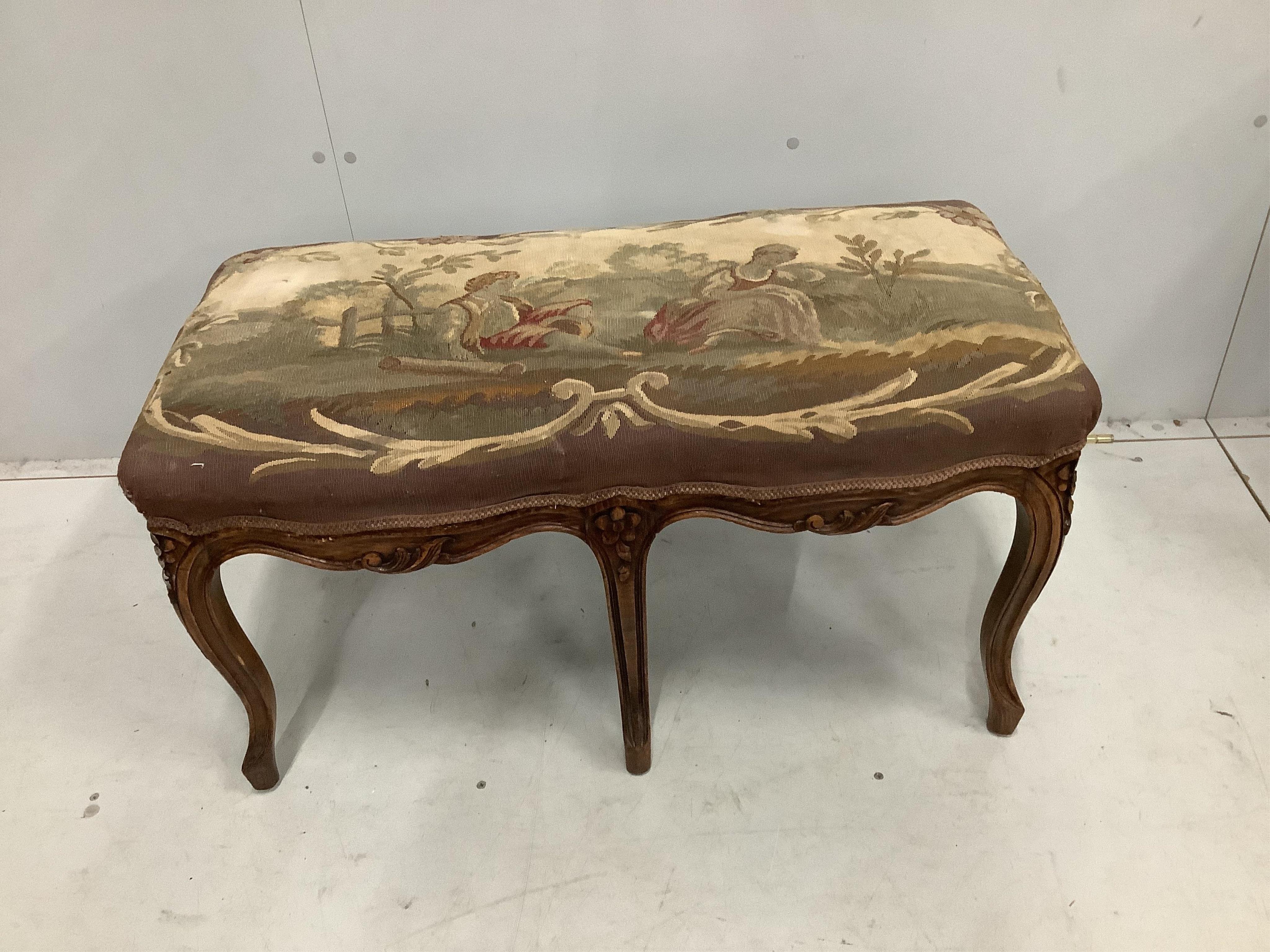 A French carved beech dressing stool, with an Aubusson style tapestry upholstered seat, width 88cm, height 46cm. Condition - fair